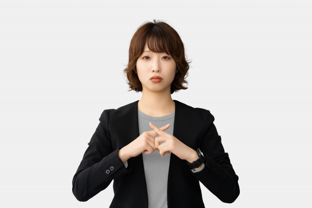 手でばつを作る女性