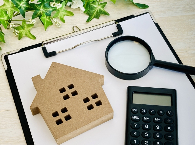 家の模型と計算機と虫眼鏡